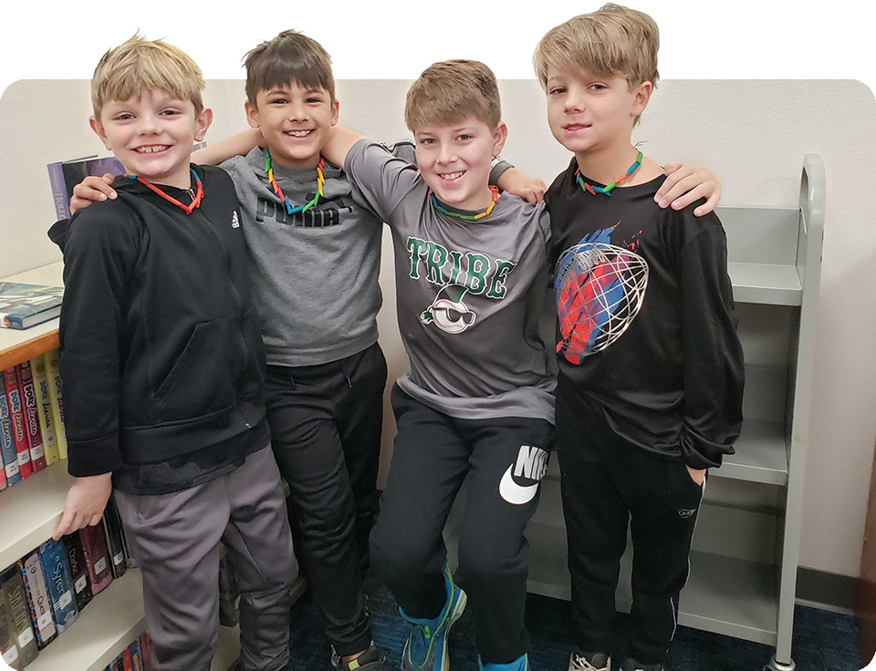 Group of boys posing with their arms around each other. 