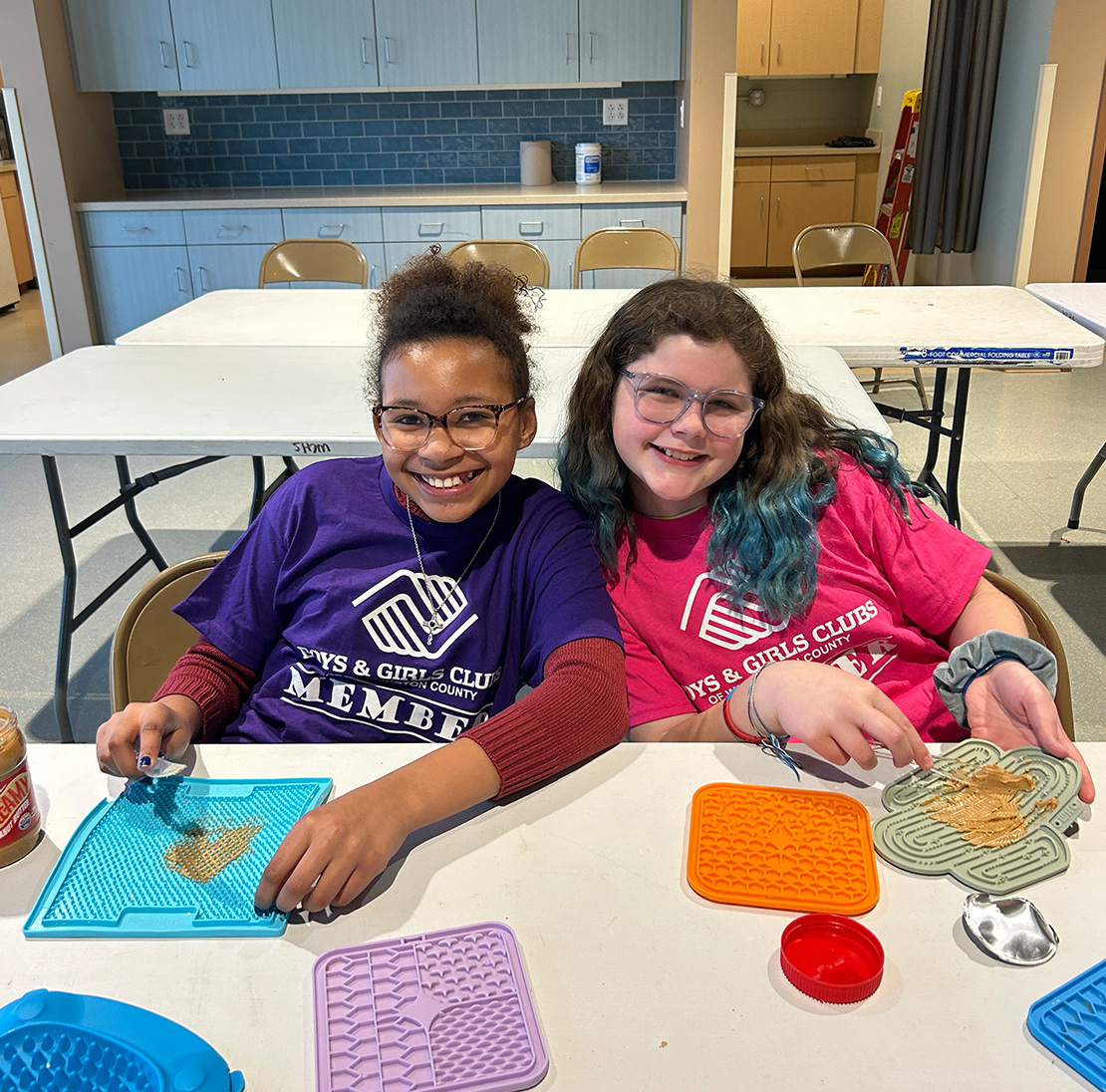 Two kids volunteering at an animal shelter.