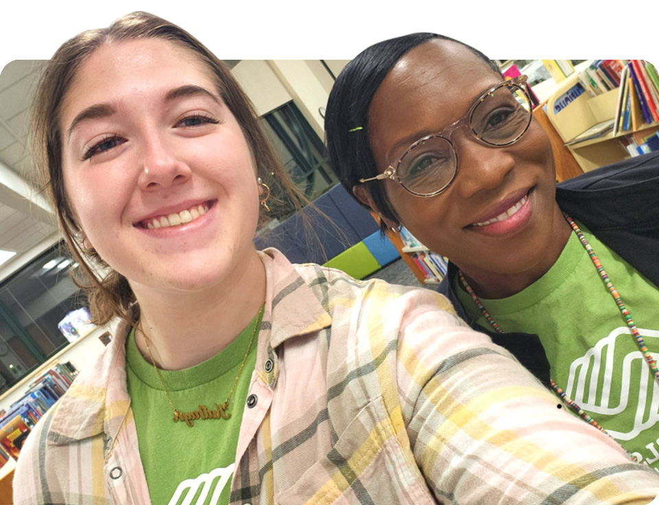 Two women in Boys and Girls club t-shirts.