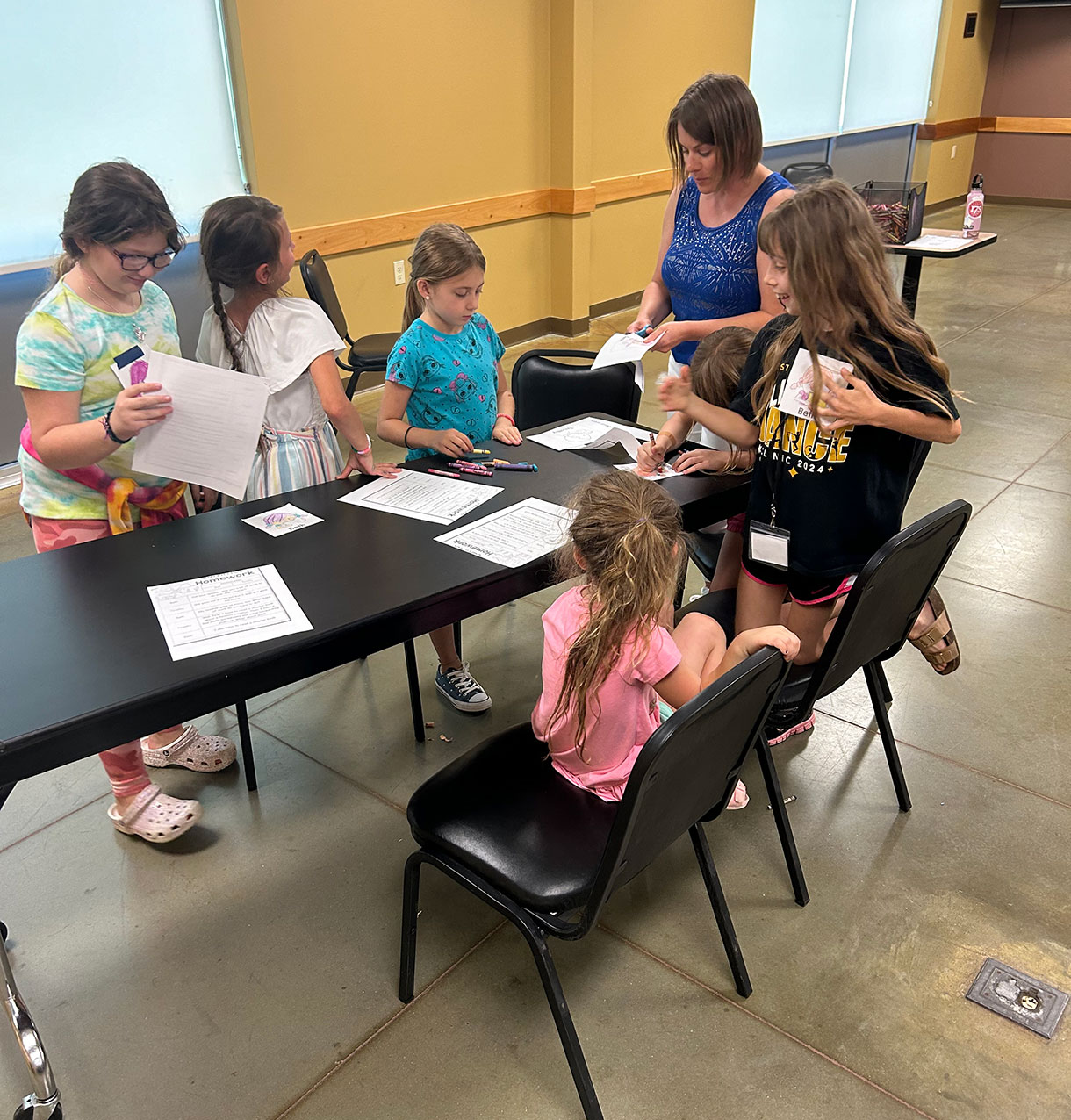 A group of volunteers using crayons for crafts around a table